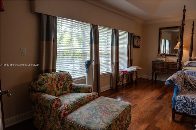 living area with plenty of natural light, crown molding, and dark hardwood / wood-style flooring