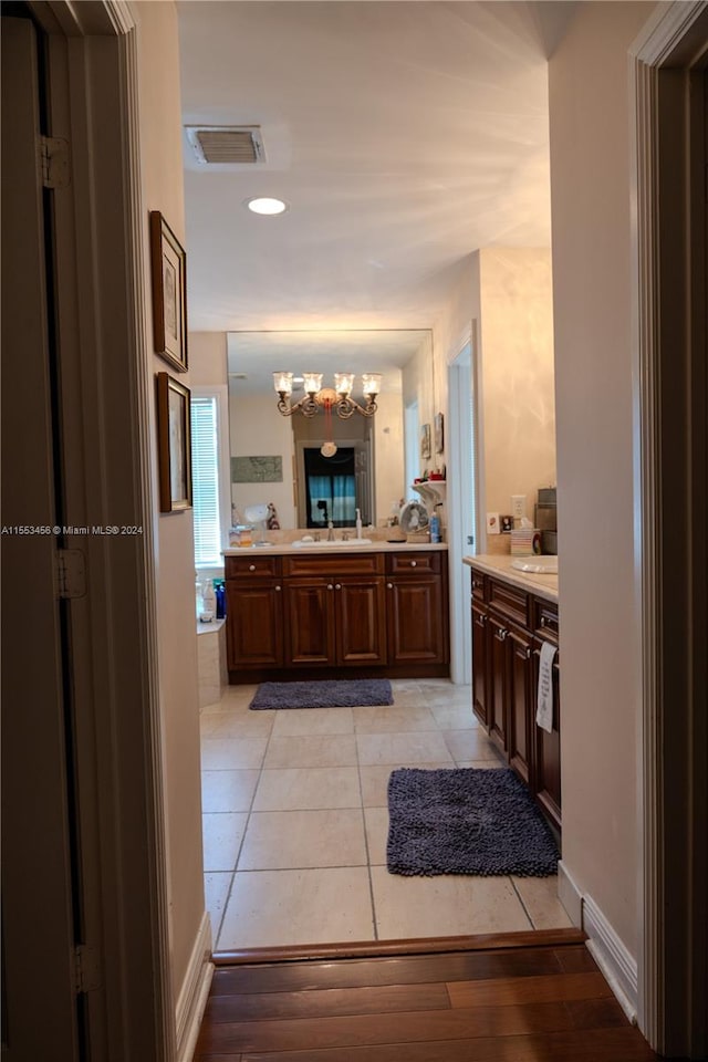 bathroom with hardwood / wood-style floors, vanity, and a chandelier