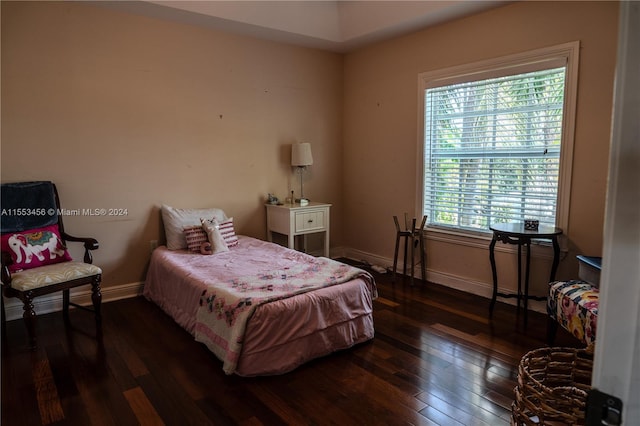 bedroom with multiple windows and dark hardwood / wood-style flooring