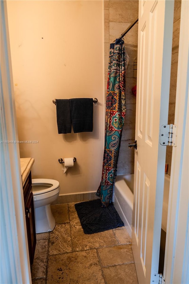 full bathroom featuring vanity, shower / bath combination with curtain, tile floors, and toilet