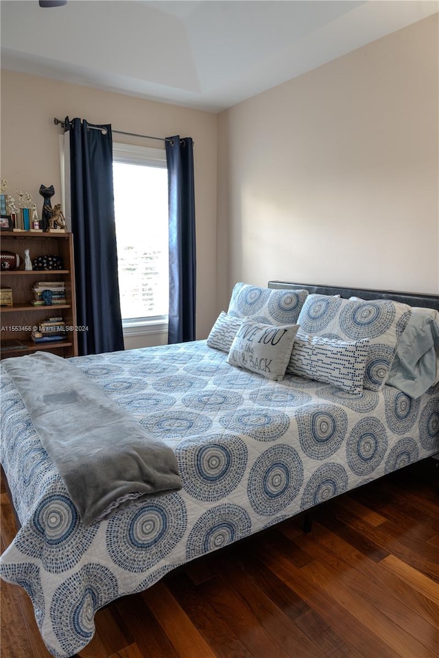 bedroom with dark hardwood / wood-style floors