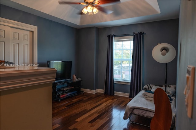 bedroom with dark hardwood / wood-style flooring and ceiling fan