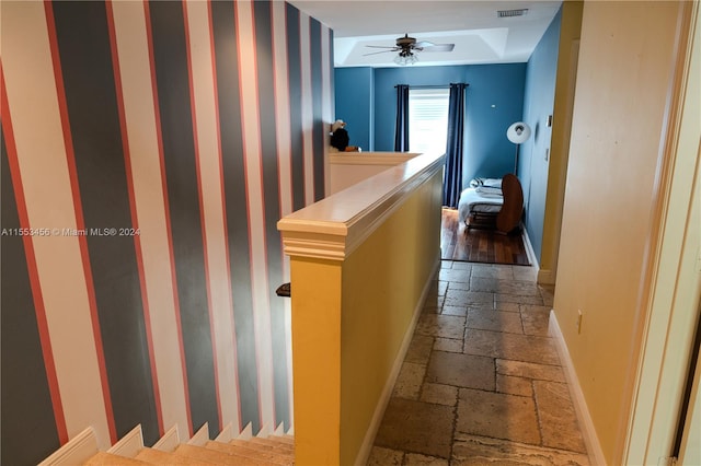 corridor featuring a raised ceiling and hardwood / wood-style floors