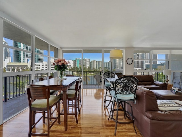 dining space with expansive windows and light wood-type flooring