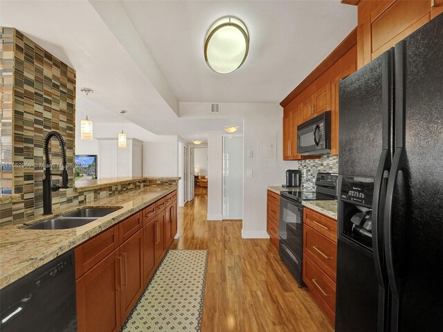 kitchen with wood-type flooring, backsplash, pendant lighting, and appliances with stainless steel finishes