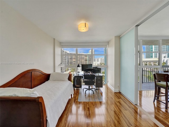 bedroom featuring floor to ceiling windows and wood-type flooring