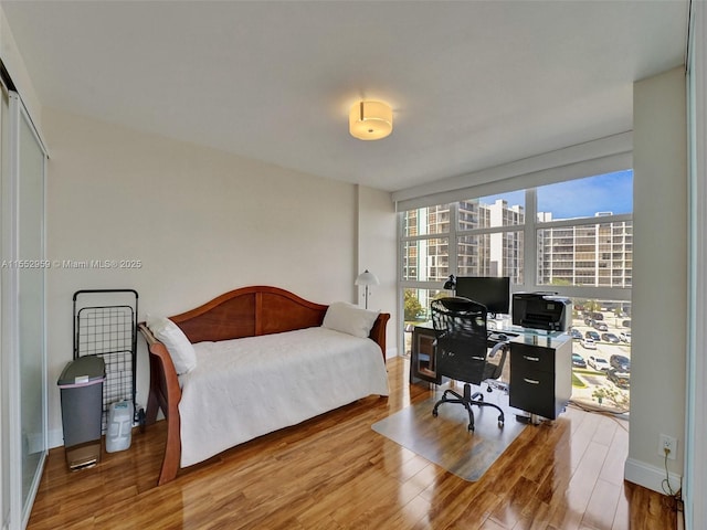 bedroom with wood-type flooring and floor to ceiling windows