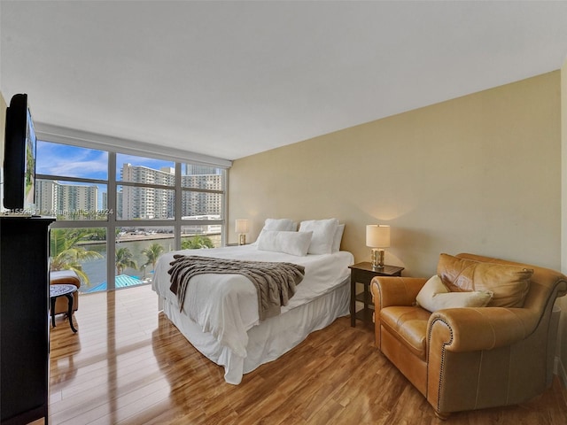 bedroom featuring light hardwood / wood-style floors and a wall of windows