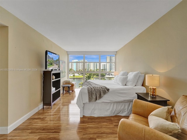 bedroom featuring floor to ceiling windows and light wood-type flooring