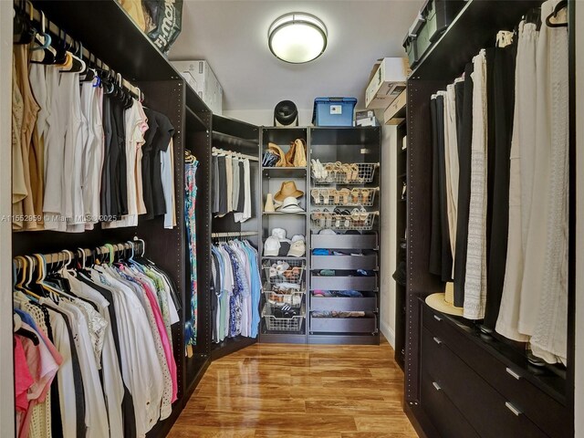 bathroom featuring toilet, a shower with shower door, a notable chandelier, double sink vanity, and wood-type flooring