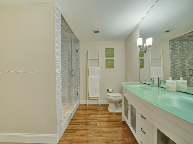 bathroom with hardwood / wood-style flooring, vanity, toilet, and walk in shower