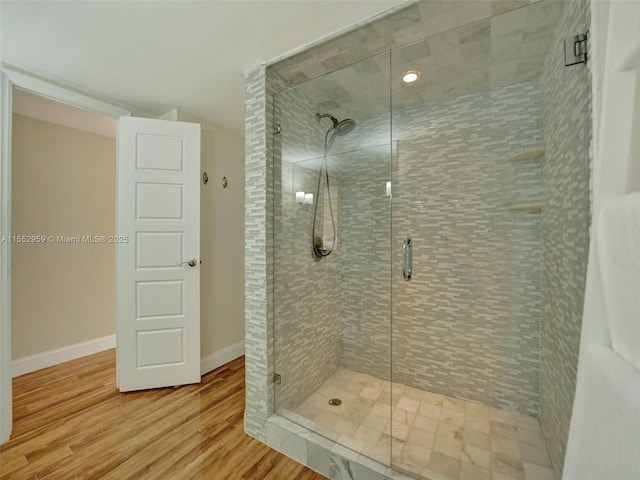 bathroom featuring hardwood / wood-style flooring and a shower with door