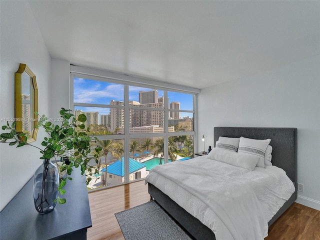 bedroom featuring expansive windows and hardwood / wood-style floors