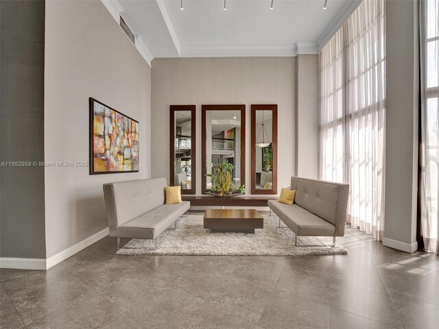 living area with ornamental molding and tile flooring