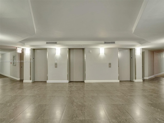 interior space featuring a tray ceiling and elevator