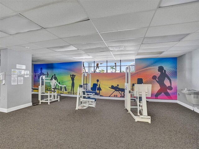 workout area with carpet floors and a drop ceiling