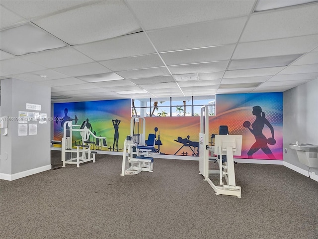 workout area with carpet flooring and a paneled ceiling