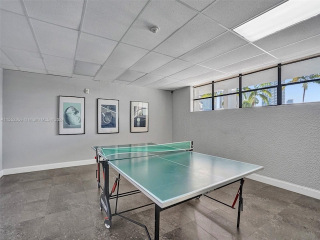 game room with dark tile floors and a drop ceiling