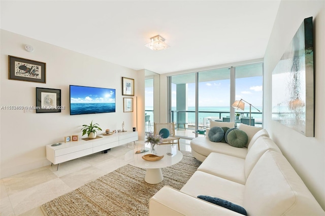 living room with floor to ceiling windows, a water view, and light tile flooring