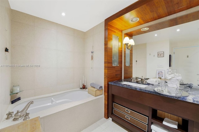 bathroom with tile walls, tiled tub, tile flooring, and vanity