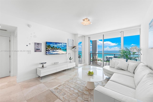 tiled living room featuring a wall of windows and a water view