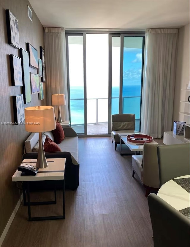 living room with hardwood / wood-style flooring, expansive windows, and a water view