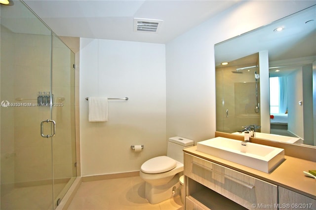 bathroom featuring toilet, vanity, tile patterned flooring, and walk in shower