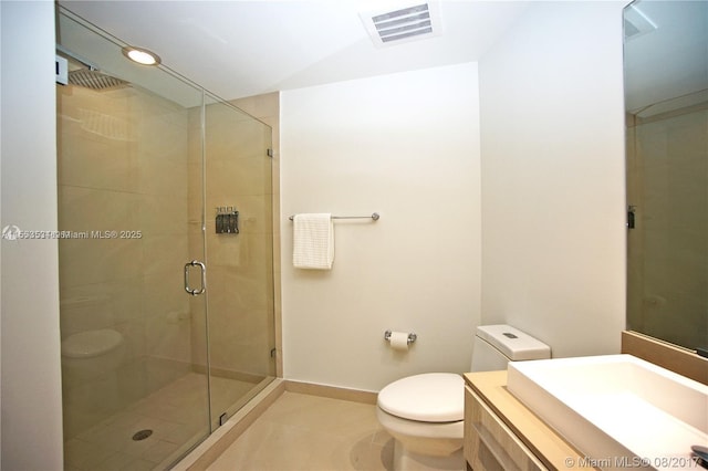 bathroom featuring toilet, vanity, tile patterned flooring, and a shower with door