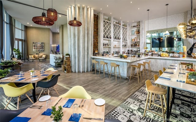 kitchen featuring decorative light fixtures, kitchen peninsula, a kitchen breakfast bar, and wood-type flooring