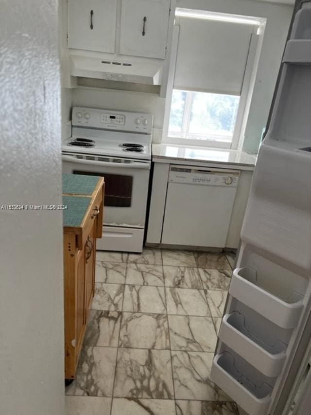 kitchen with light tile flooring, white appliances, and white cabinetry