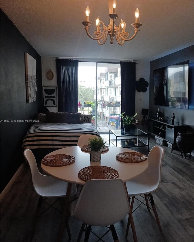 dining space with wood-type flooring and a notable chandelier