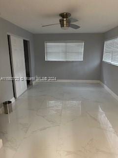 tiled empty room featuring ceiling fan