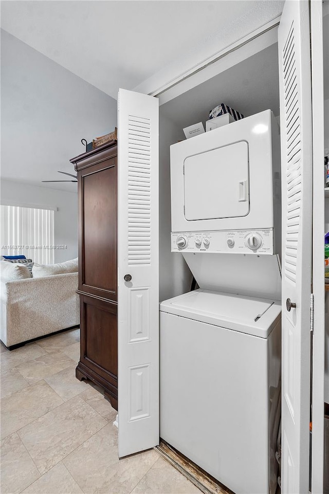 washroom featuring light tile patterned floors and stacked washer and dryer