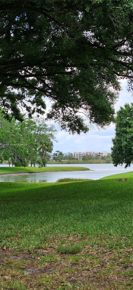 view of community featuring a water view and a lawn