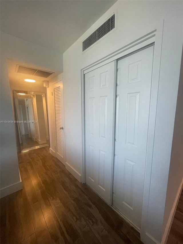 hallway with dark hardwood / wood-style flooring