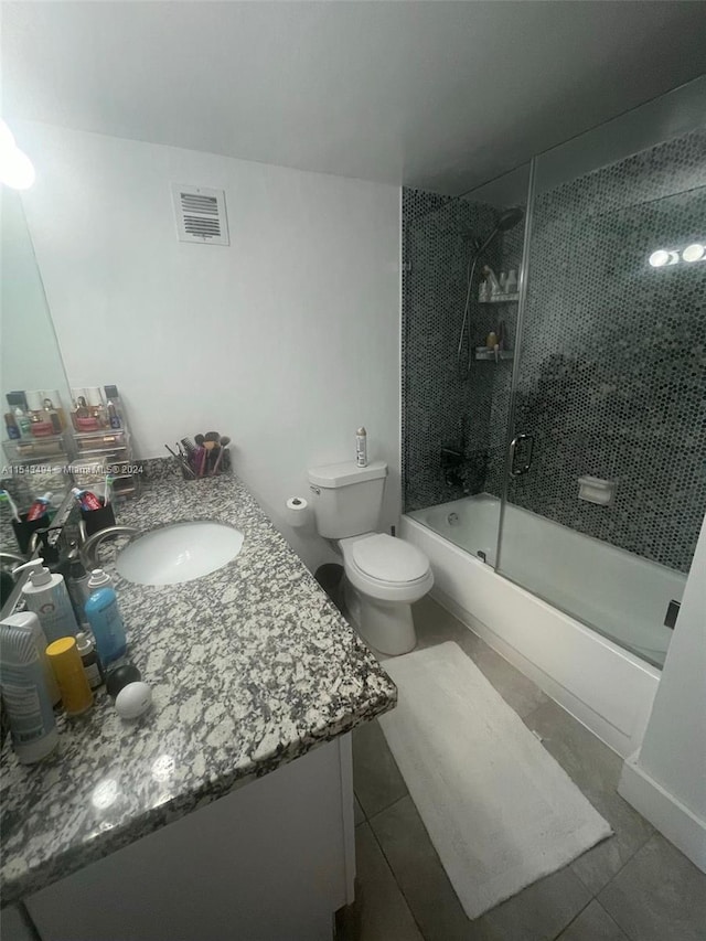 full bathroom with toilet, combined bath / shower with glass door, tile floors, and vanity