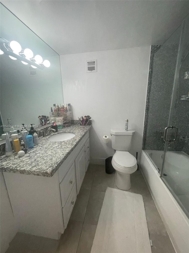 full bathroom featuring toilet, combined bath / shower with glass door, tile flooring, and vanity