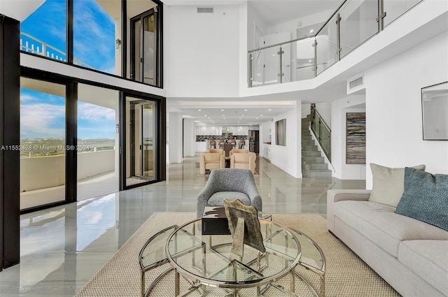 living room featuring french doors, light tile floors, and a towering ceiling