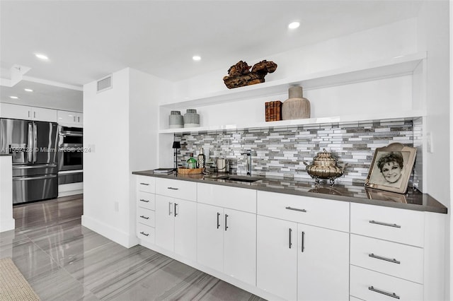 kitchen with sink, fridge, tasteful backsplash, and white cabinets