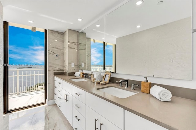 bathroom with expansive windows, dual bowl vanity, tile floors, and a tile shower