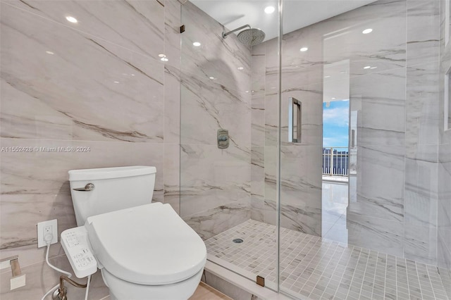 bathroom with tile walls, a shower with door, and toilet