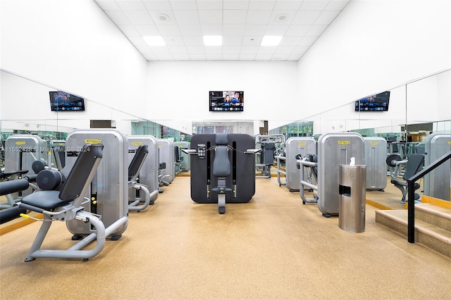 workout area with a paneled ceiling and a towering ceiling