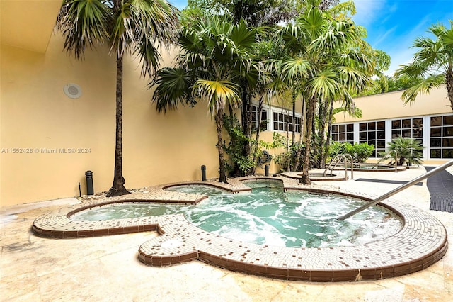 view of pool featuring a patio and an in ground hot tub