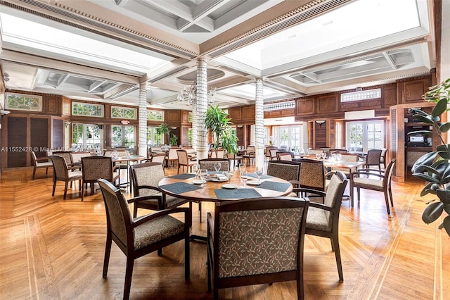 dining space featuring beam ceiling, coffered ceiling, a notable chandelier, and light parquet floors