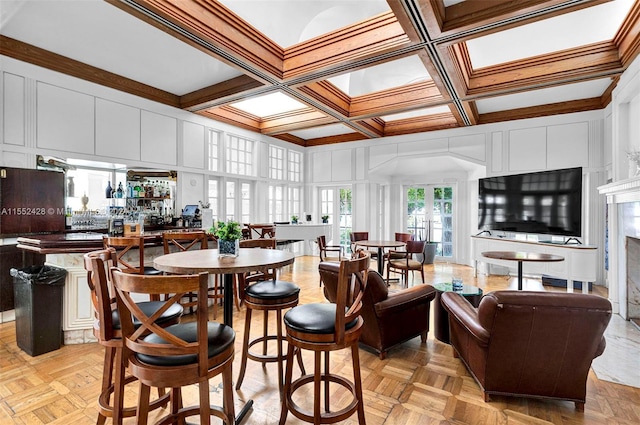 dining room featuring coffered ceiling, light parquet floors, and french doors