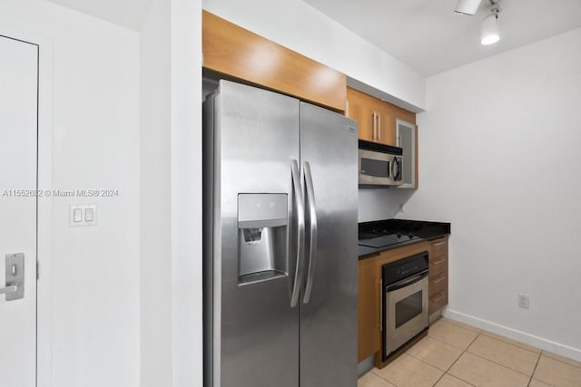 kitchen with stainless steel appliances and light tile flooring