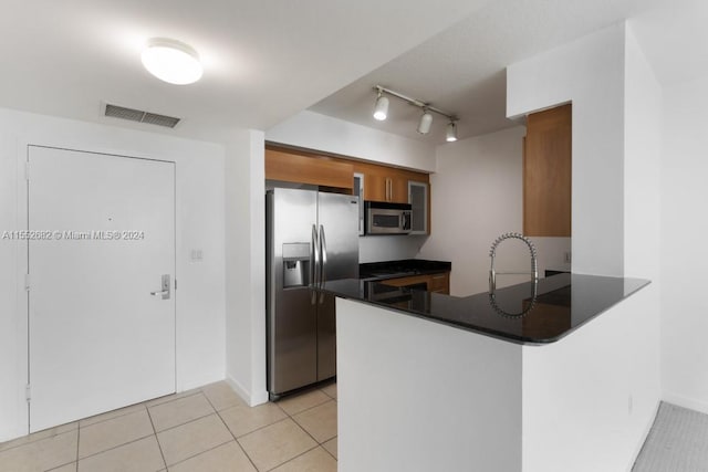 kitchen featuring kitchen peninsula, light tile floors, stainless steel appliances, and track lighting