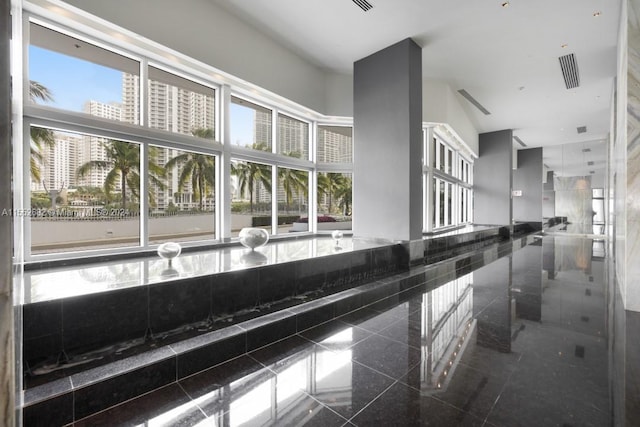 hallway with dark tile flooring and a high ceiling