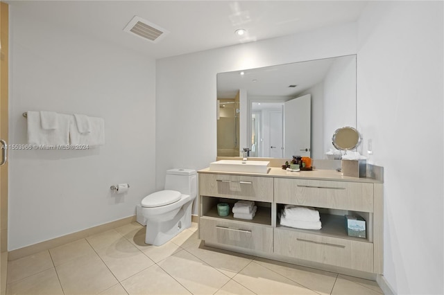 bathroom featuring toilet, tile floors, and vanity