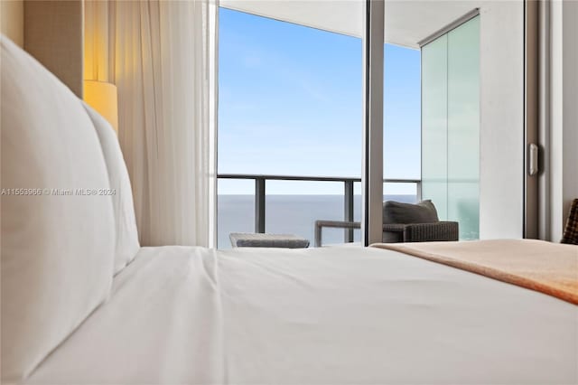 bedroom featuring floor to ceiling windows and a water view